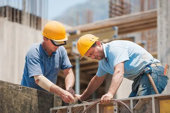 Two workers wearing hard hats at a construction site